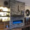 Grey drystacked real dimensional ledgestone veneer on an interior fireplace