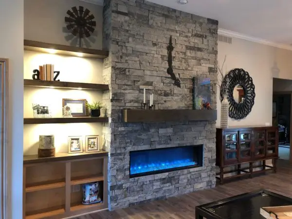 Grey drystacked real dimensional ledgestone veneer on an interior fireplace