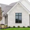 Residential exterior with machine cut limestone thin veneer and white mortar.