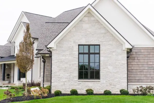 Residential exterior with machine cut limestone thin veneer and white mortar.