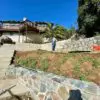 Stone being installed over a block retaining wall