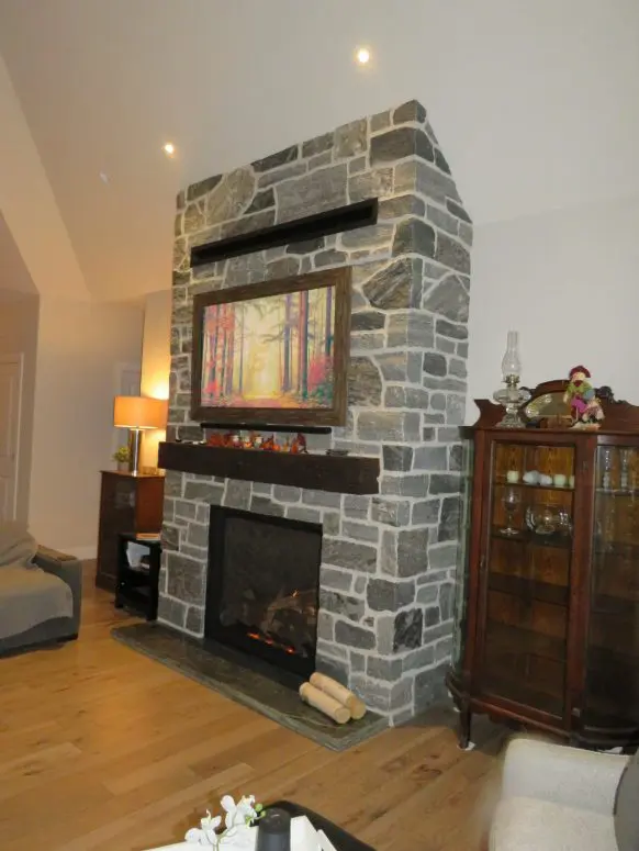 Timmins Natural Stone Veneer with Custom Dark Pieces Living Room Fireplace
