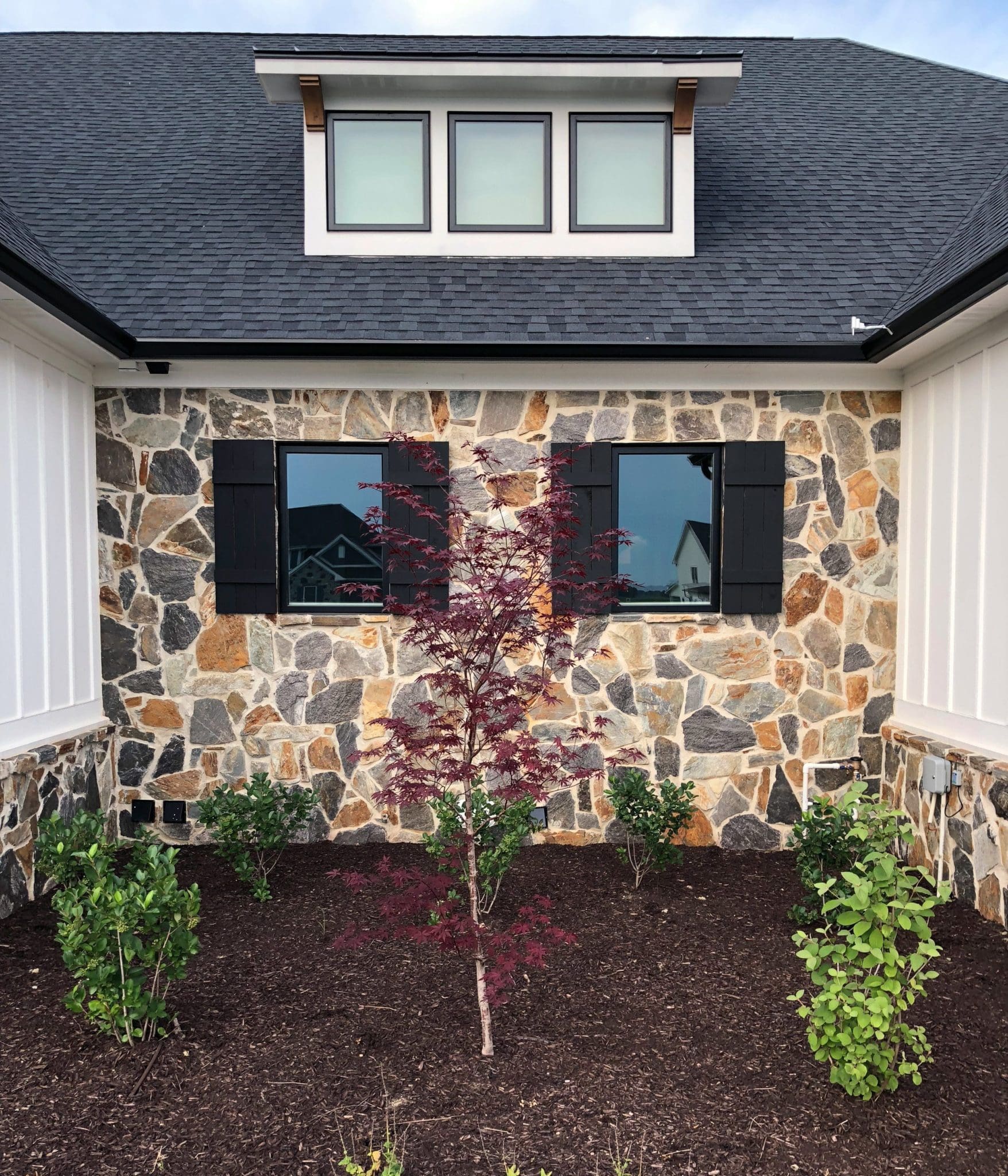 Exterior accent wall and wainscoting with Bonavista and Black Sands real stone veneer